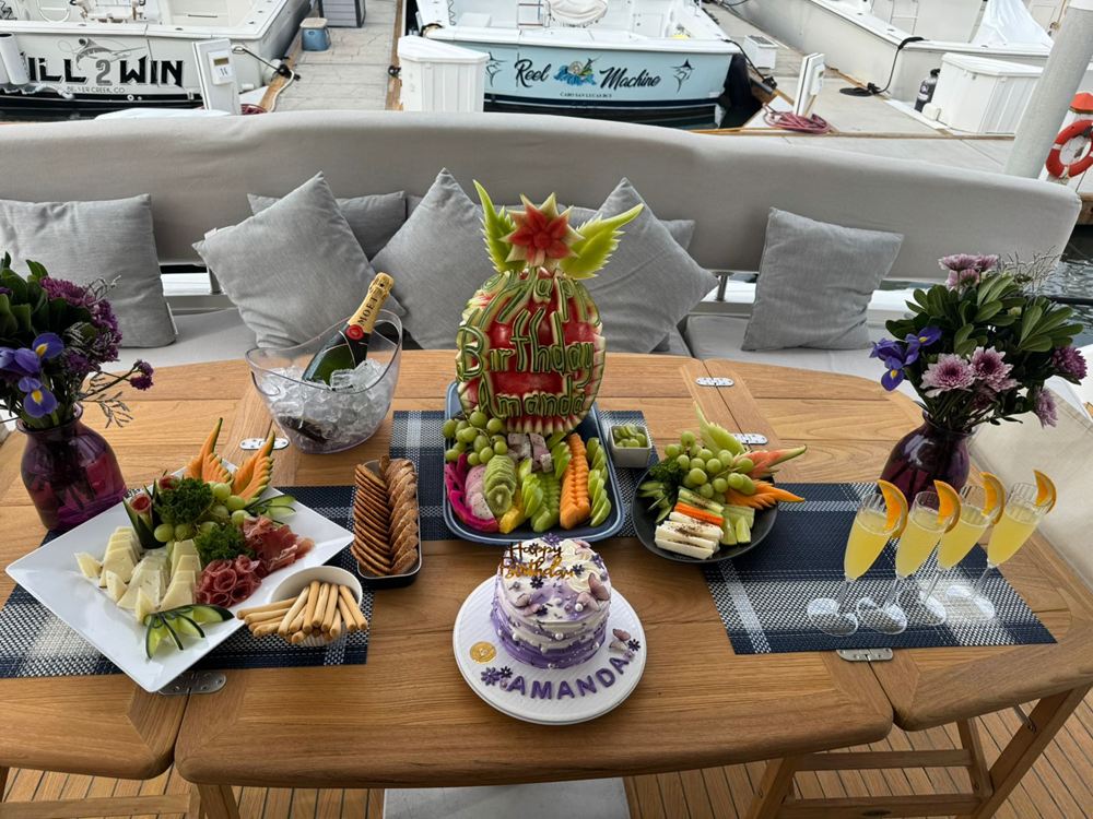 Lunch spread with fruit, salads and flowers on a yacht's teak deck table
