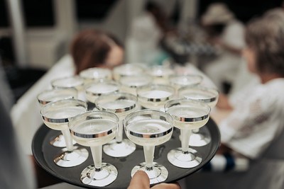 Tray of champagne glasses being carried to guests on a boat